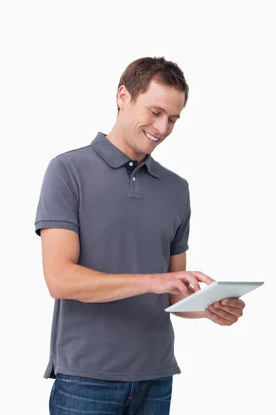 Uśmiechający się młody człowiek pracuje na swoim komputerze typu tablet — Zdjęcie stockowe