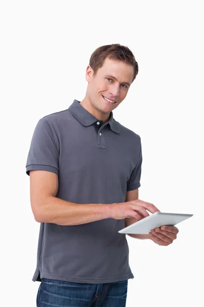 Tablet bilgisayar ile genç adam gülümsüyor — Stok fotoğraf