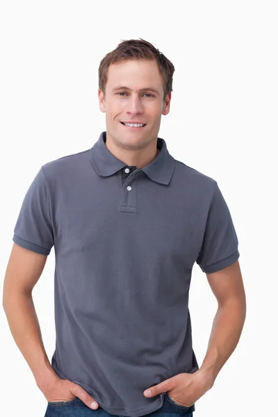 Улыбающийся молодой мужчина с руками в карманах — стоковое фото