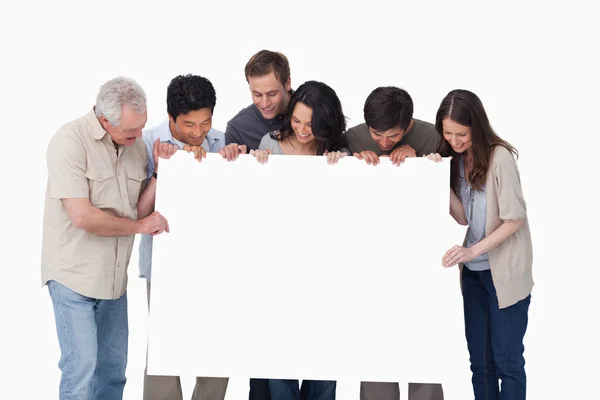 Group looking at blank sign in their hand — Stock Photo, Image