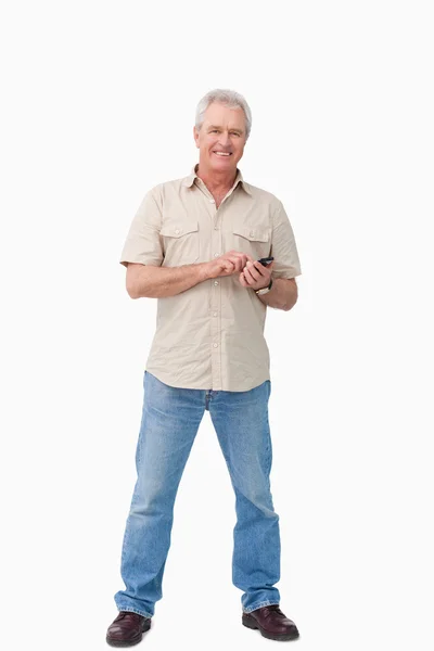 Uśmiechnięta dojrzałych mężczyzn z jego telefon — Zdjęcie stockowe