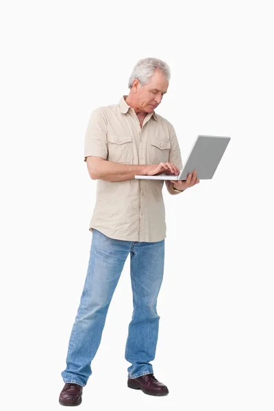 Dojrzały mężczyzna pracuje na swoim laptopie — Zdjęcie stockowe