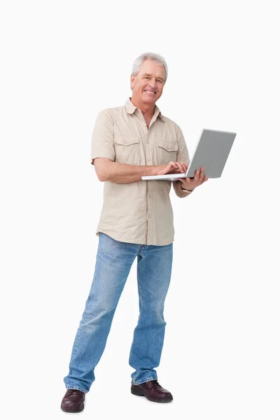 Uśmiechający się dojrzały mężczyzna z laptopem — Zdjęcie stockowe
