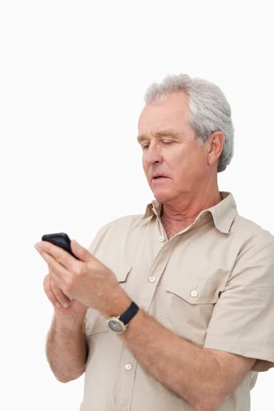 Dojrzały człowiek pisania SMS na swój telefon komórkowy — Zdjęcie stockowe