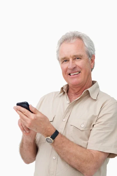 Lächelnder älterer Mann tippt eine SMS — Stockfoto