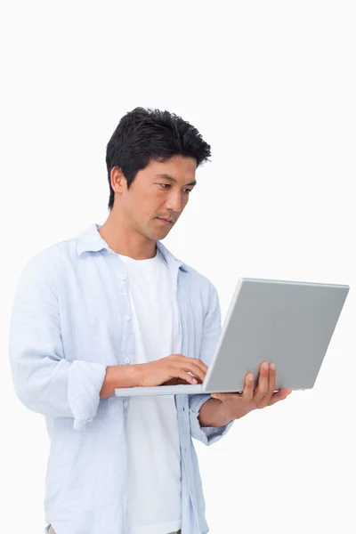 Ung man arbetar på sin laptop — Stockfoto