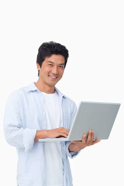Hombre sonriente con su portátil — Foto de Stock