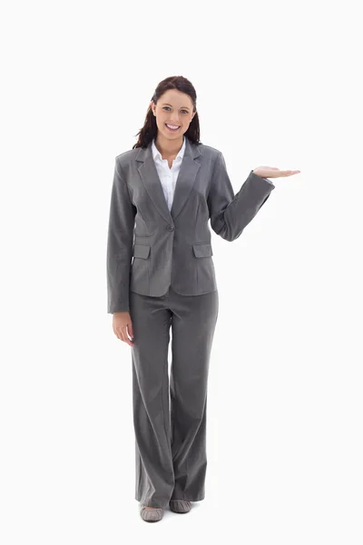 Geschäftsfrau lächelt und präsentiert ein Produkt — Stockfoto