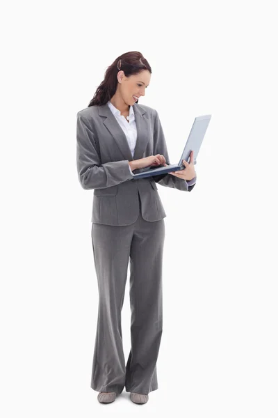 Geschäftsfrau lächelt, während sie ihren Laptop betrachtet — Stockfoto