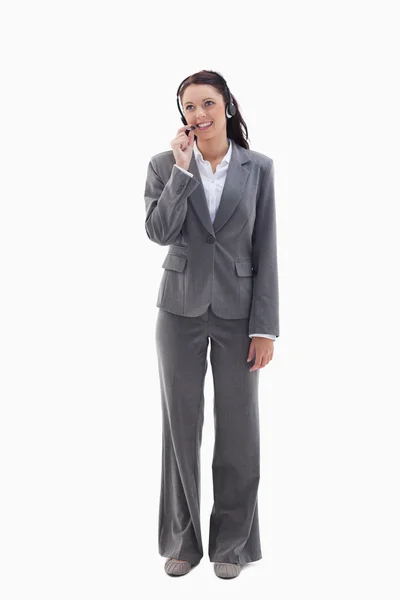 Geschäftsfrau schaut oben zu, wie sie mit einem Headset spricht — Stockfoto