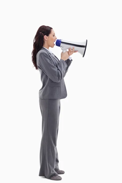 Profile of a businesswoman speaking loudly in a megaphone — Stock Photo, Image