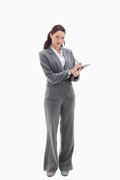 Businesswoman writing on a clipboard — Stock Photo, Image