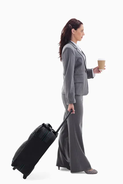 Perfil de uma mulher de negócios com uma mala e segurando um café — Fotografia de Stock