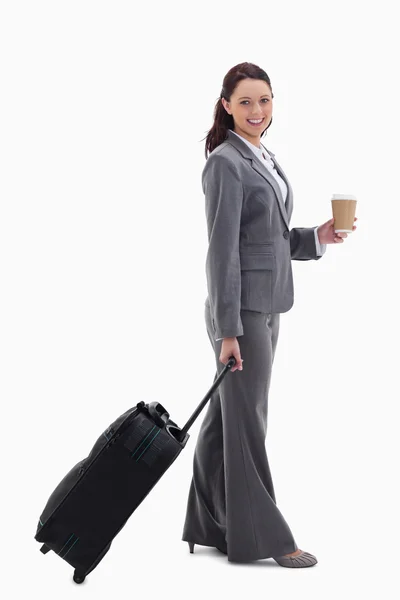 Profili bir bavulla gülümseyerek ve tutan bir iş kadını, bir — Stok fotoğraf