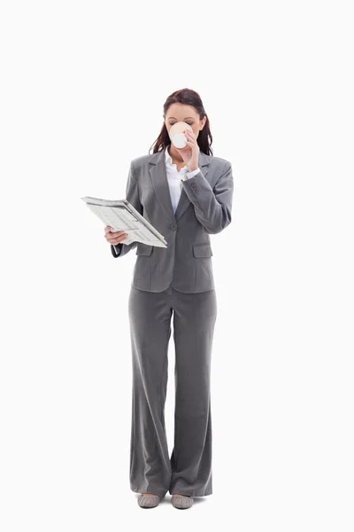 Geschäftsfrau trinkt einen Kaffee und liest eine Zeitung — Stockfoto
