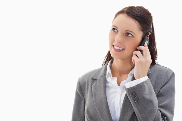 Close up de uma mulher de negócios olhando para cima, enquanto sorrindo no phon — Fotografia de Stock