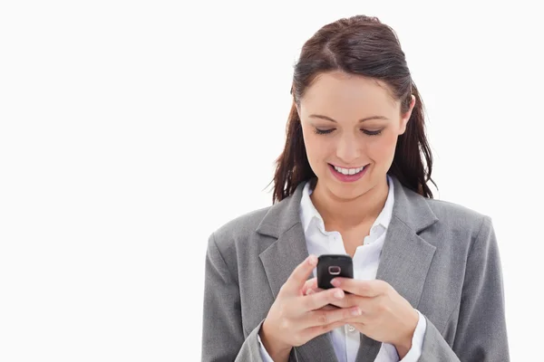 Primer plano de una mujer de negocios sonriendo y escribiendo un mensaje de texto —  Fotos de Stock