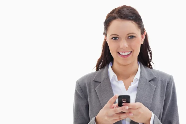 Mujer de negocios sonriendo y sosteniendo su móvil — Foto de Stock