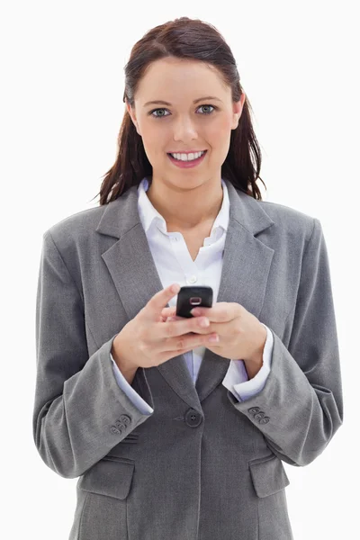 Primer plano de una mujer de negocios sonriendo y sosteniendo su móvil — Foto de Stock