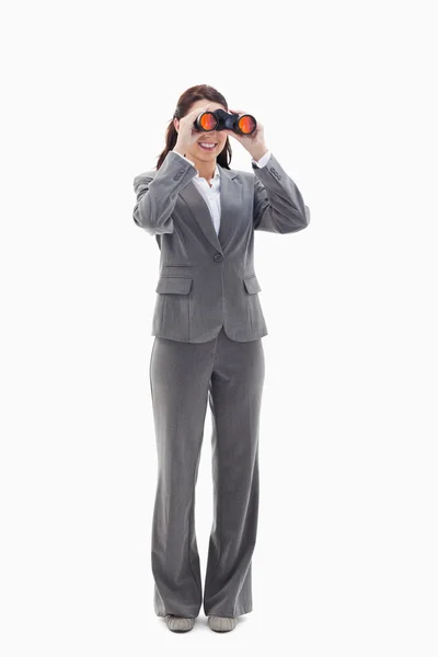 Mujer de negocios sonriendo y mirando a través de los prismáticos —  Fotos de Stock