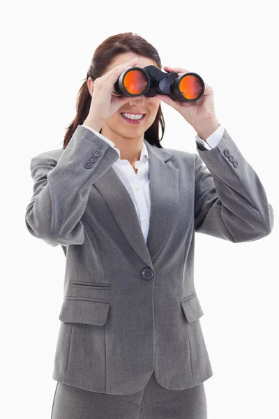 Close-up of a businesswoman smiling and looking through binocula — Stock Photo, Image