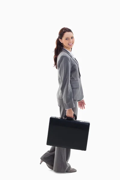 Profile of a business woman smiling and walking with a briefcase — Stock Photo, Image