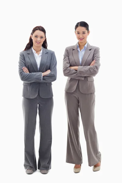 Två kvinnliga företagare leende och korsar armarna — Stockfoto