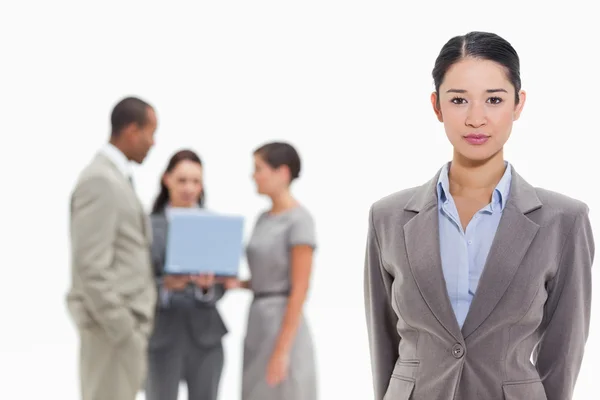 Serious businesswoman with co-workers in the background — Stock Photo, Image