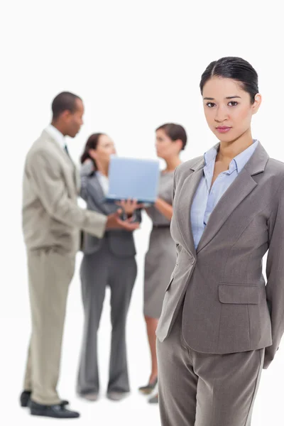 Ernstige zakenvrouw met collega's op de achtergrond — Stockfoto