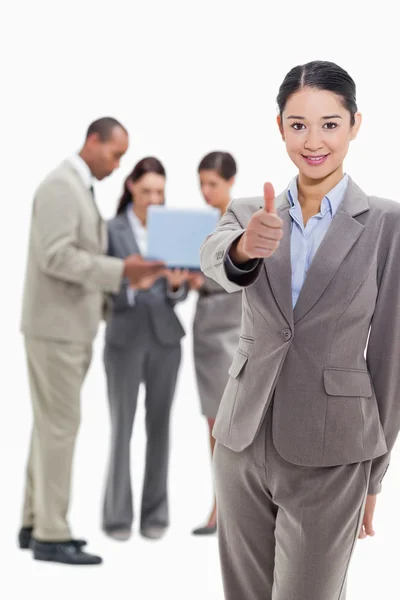 Affärskvinna leende och godkännande med medarbetare i backg — Stockfoto