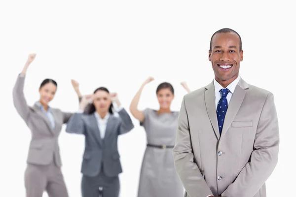 Gelukkig zakenman met enthousiaste collega's op de achtergrond — Stockfoto