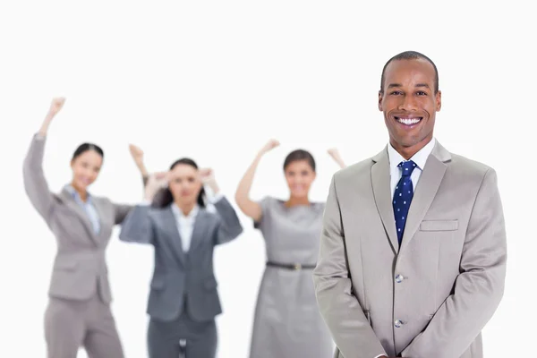 Feliz hombre de negocios con entusiastas compañeros de trabajo en el fondo —  Fotos de Stock