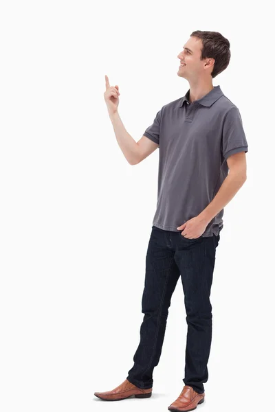 Homem sorrindo em pé e apresentando algo acima — Fotografia de Stock