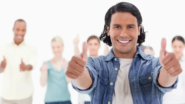 Close-up of a man with his thumbs-up with behind — Stock Photo, Image