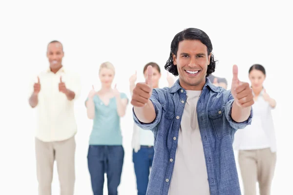 Close-up of a man smiling with his thumbs-up with behind — Stock Photo, Image
