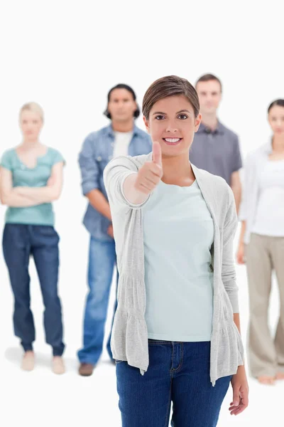 Close-up of a woman giving the thumb-up with behind — Stock Photo, Image