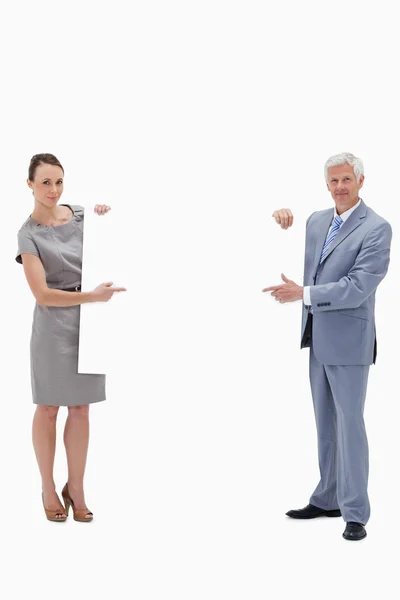 White hair businessman holding and pointing to a big white sign — Stock Photo, Image