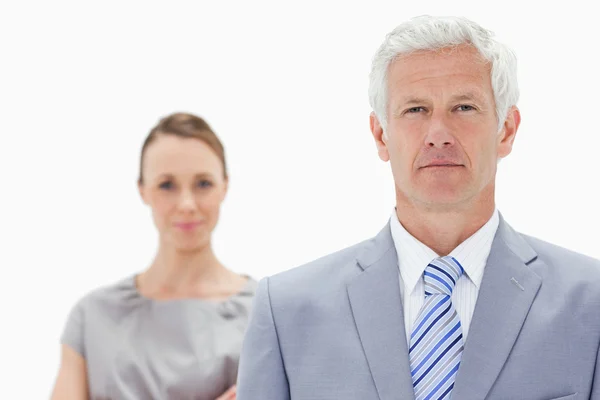 Close-up of a serious white hair businessman with a woman behind — Stock Photo, Image