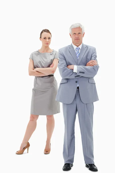 White hair businessman with a woman behind him crossing their ar — Stock Photo, Image