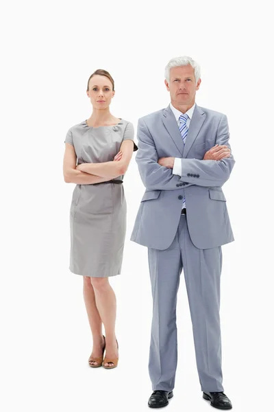 White hair businessman with a woman behind him crossing their ar — Stock Photo, Image