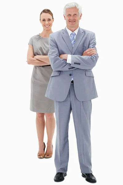 Bílé vlasy podnikatel s ženou v pozadí usmívá a cr — Stock fotografie