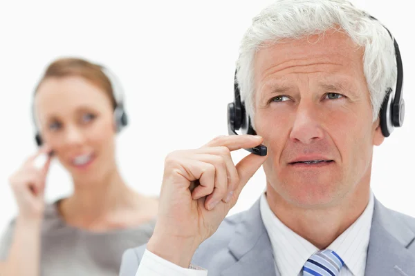 Close-up of a white hair man with a woman talking in background — Stock Photo, Image