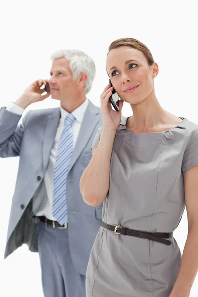 Primer plano de una mujer haciendo una llamada con un hombre de negocios de cabello blanco — Foto de Stock