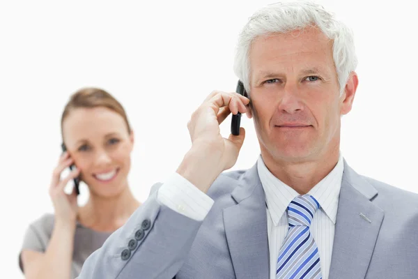 Κοντινό πλάνο ενός επιχειρηματία άσπρα μαλλιά στο τηλέφωνο με ένα χαμόγελο — Φωτογραφία Αρχείου