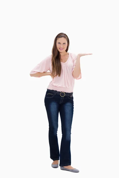 Young woman presenting with her hand on her hip — Stock Photo, Image