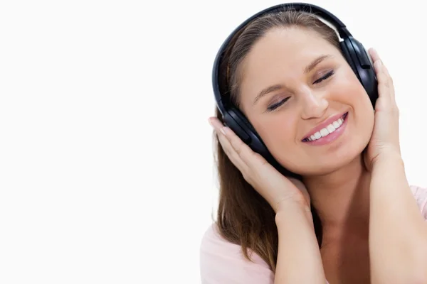 Close-up de uma menina sorridente ouvindo música — Fotografia de Stock