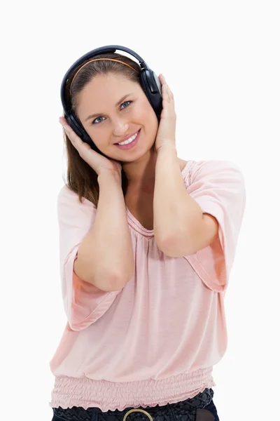 Menina com camisa rosa usando fones de ouvido contra fundo branco — Fotografia de Stock