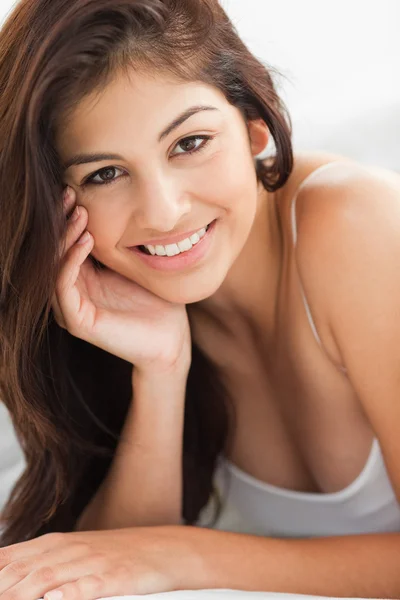 Close up of woman with a hand against her cheek, smiling and loo — Stock Photo, Image