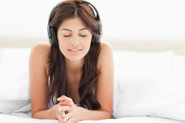 Kvinna med hennes ögon stängda lyssnar och njuter av musik o — Stockfoto