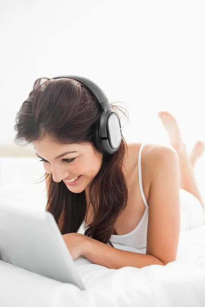 Close up, woman on the bed using a tablet and headphones with he — Stock Photo, Image
